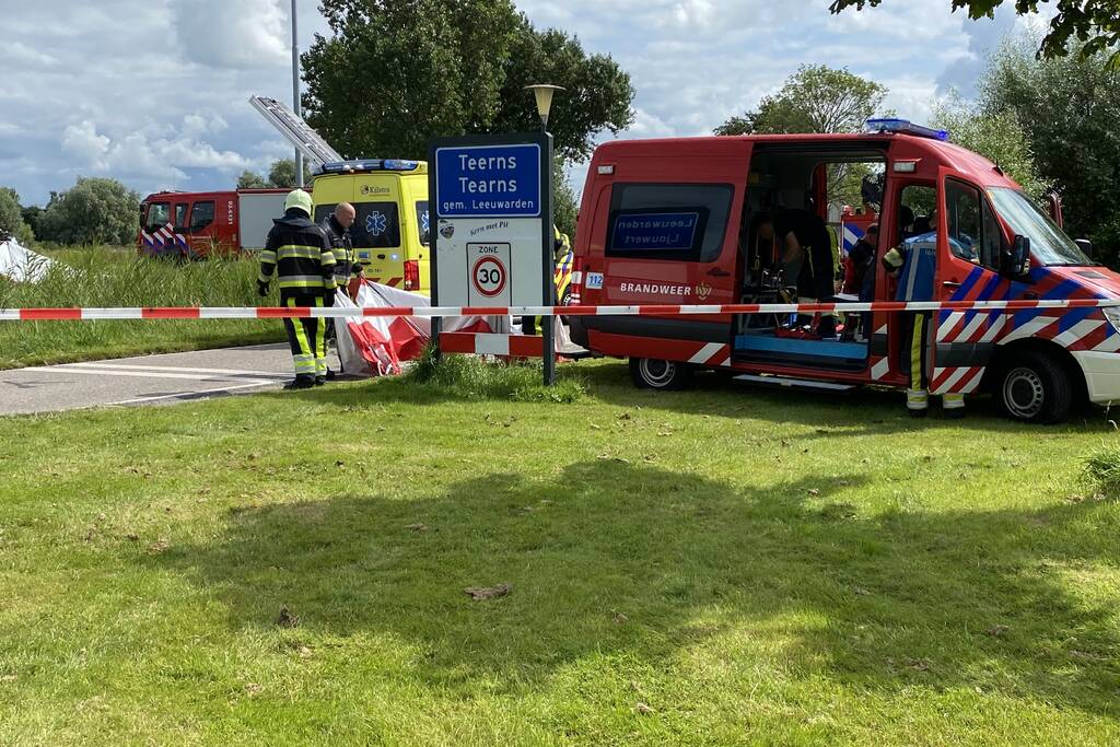 Auto schiet van de weg en belandt ondersteboven in het water