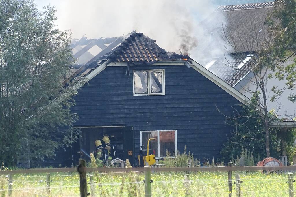 Dikke zwarte rookwolken bij grote brand in schuur