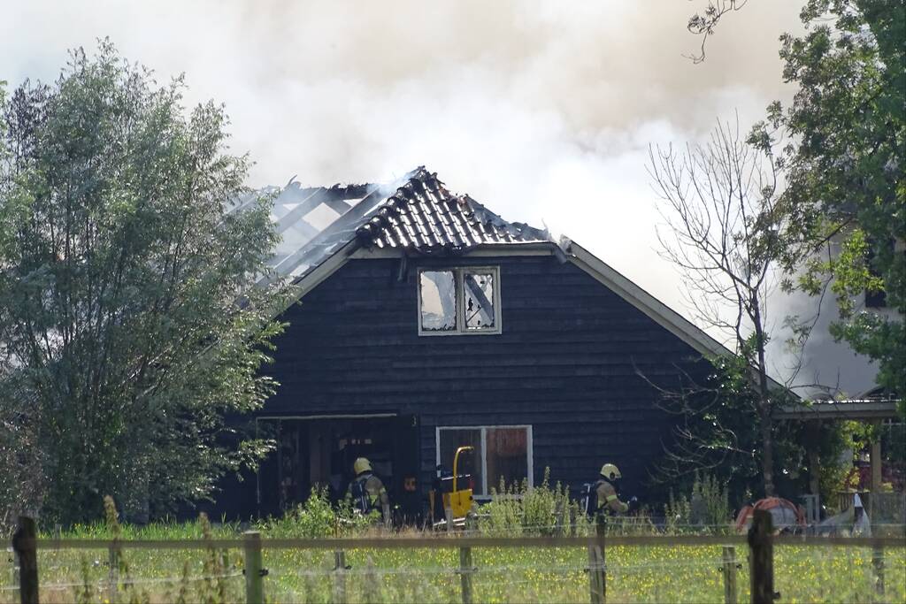 Dikke zwarte rookwolken bij grote brand in schuur
