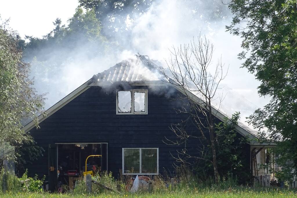 Dikke zwarte rookwolken bij grote brand in schuur