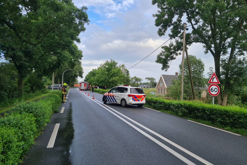 Bezorgauto slaat over de kop en ramt stroommast