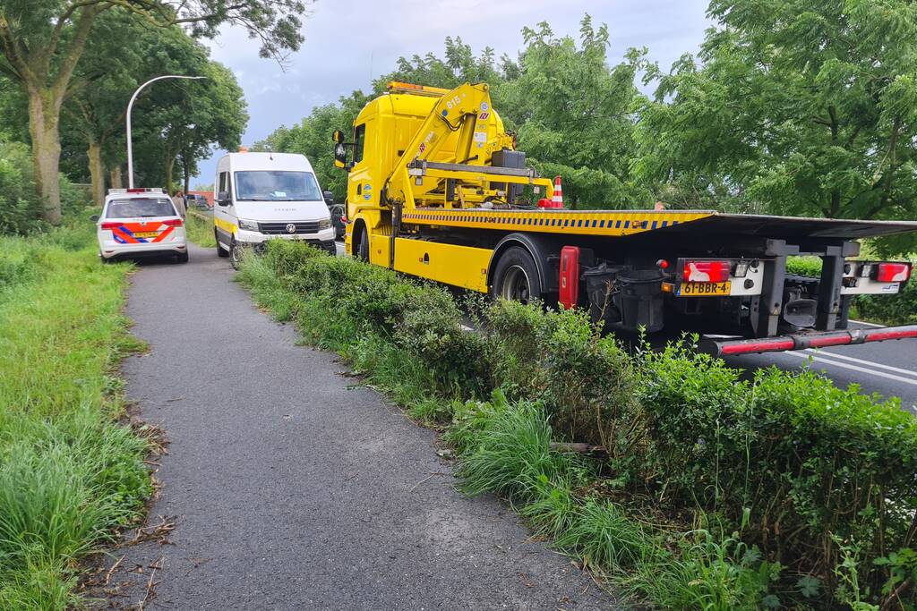 Bezorgauto slaat over de kop en ramt stroommast