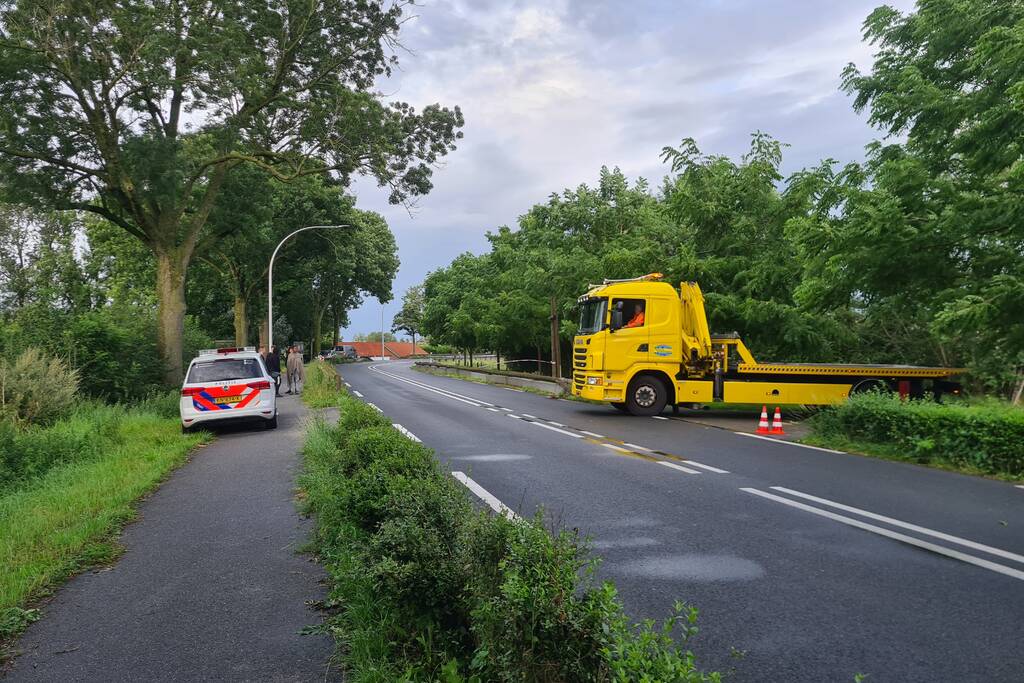Bezorgauto slaat over de kop en ramt stroommast