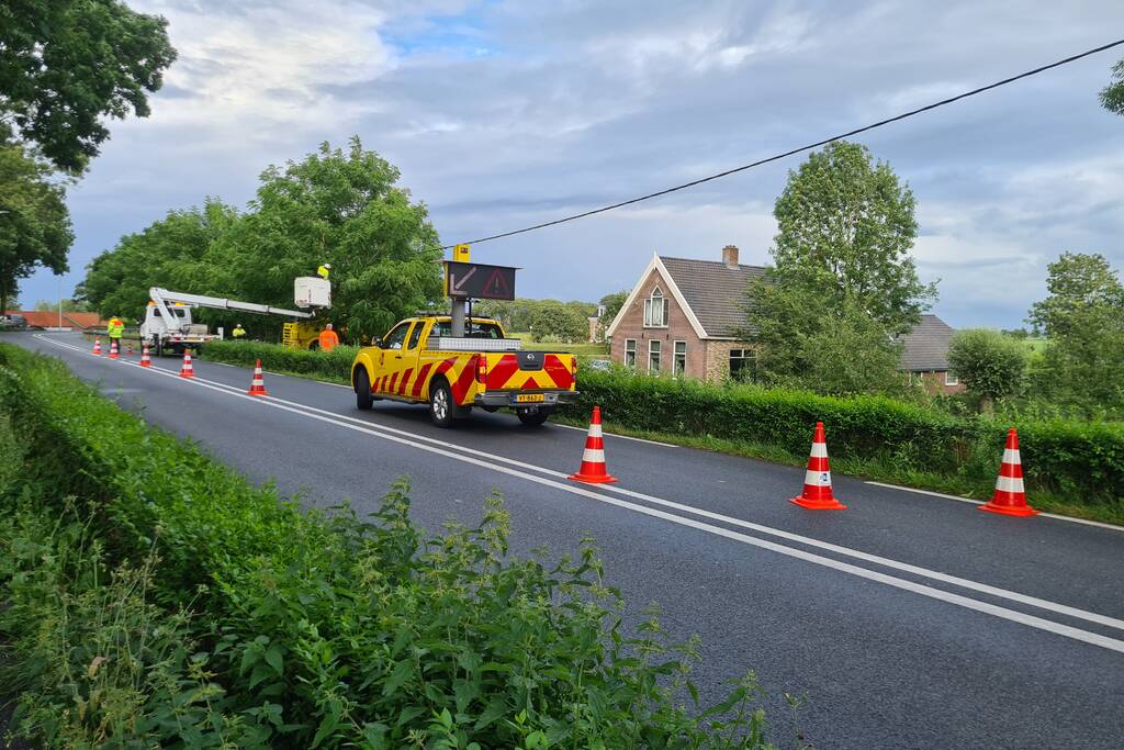 Bezorgauto slaat over de kop en ramt stroommast
