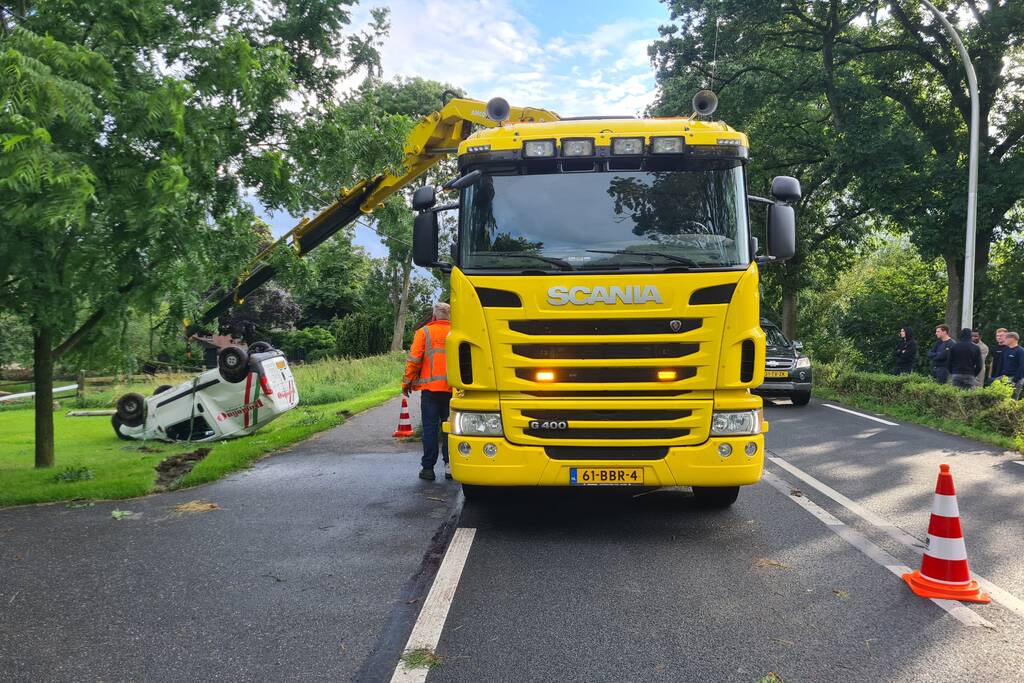 Bezorgauto slaat over de kop en ramt stroommast