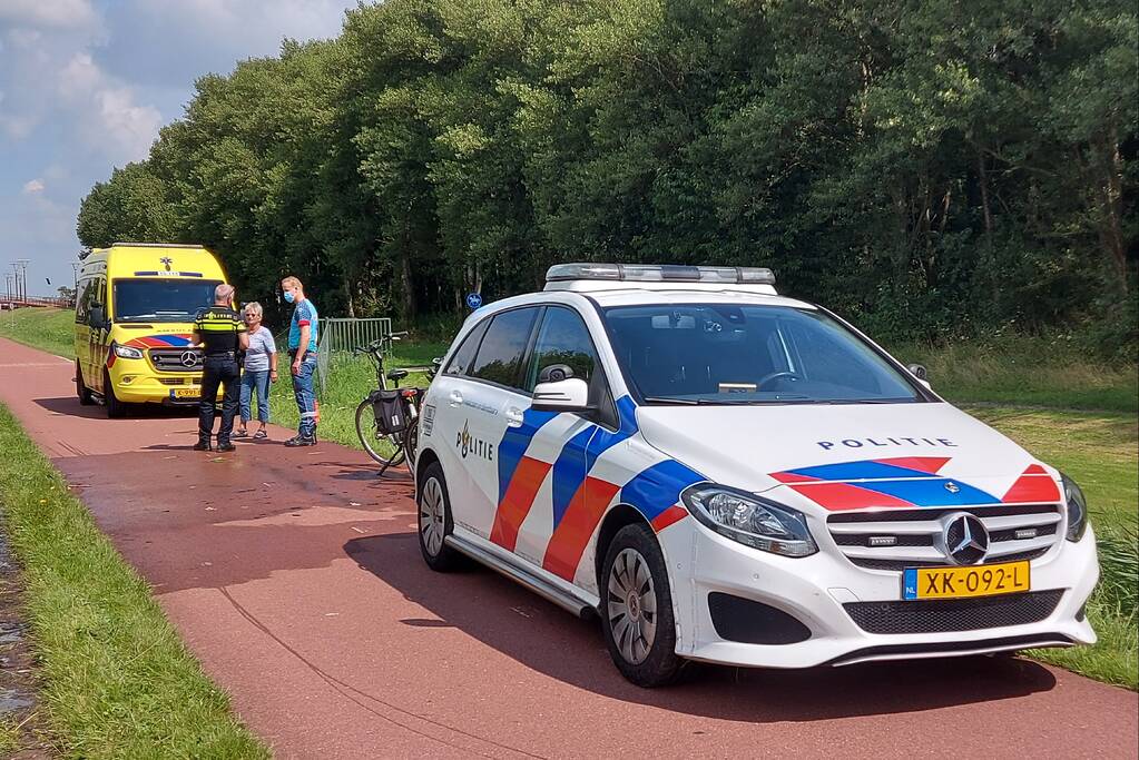 Vrouw rijdt met fiets sloot in
