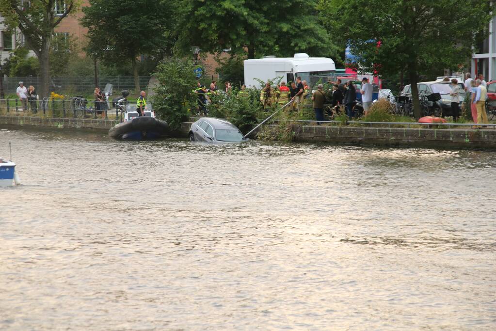 Personenauto verdwijnt onder water