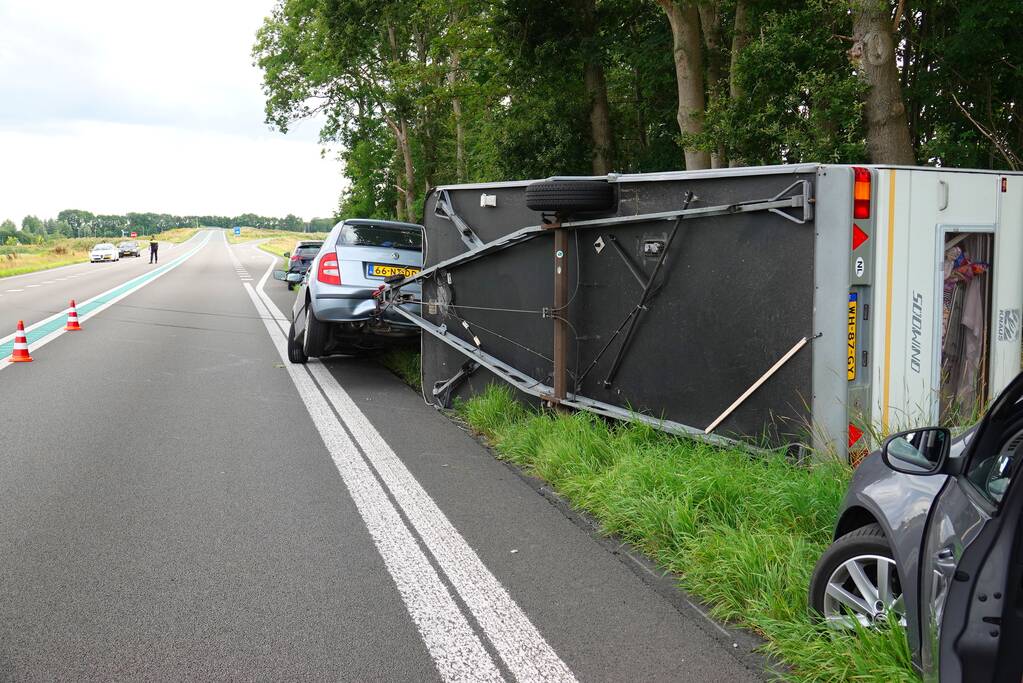 Auto met caravan belandt op zijn kant
