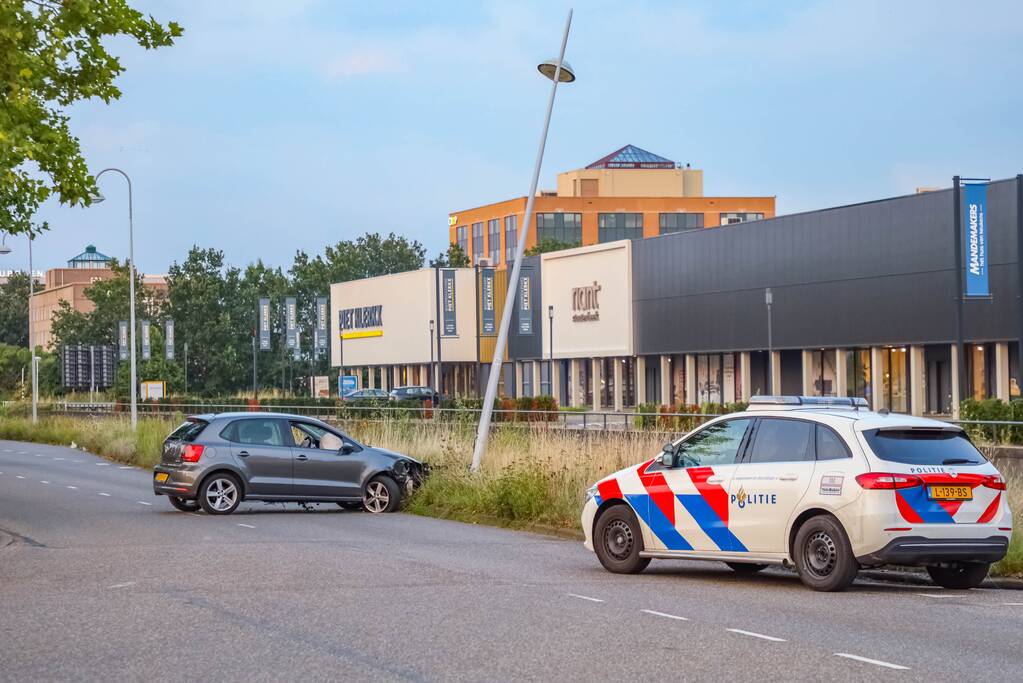 Auto knalt op lantaarnpaal
