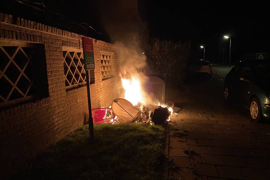 Brandweer blust brand bij container