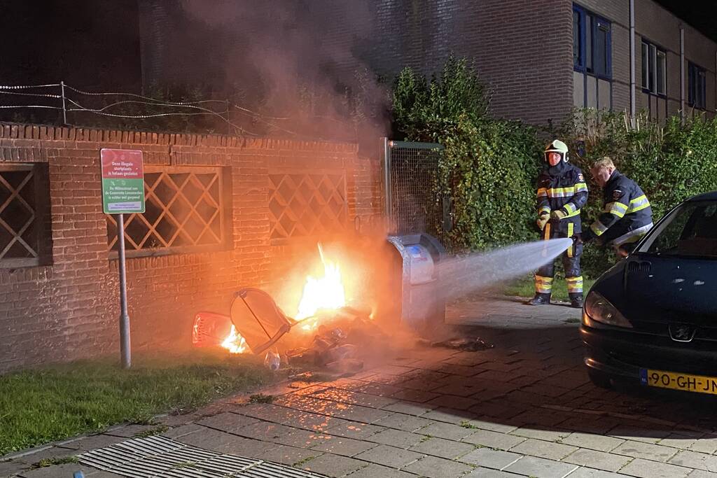 Brandweer blust brand bij container