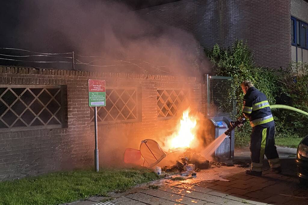 Brandweer blust brand bij container