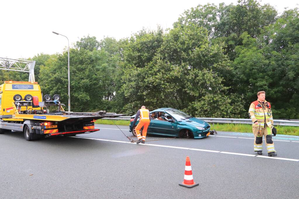 Auto glijdt over vangrail heen en belandt op zijn kop
