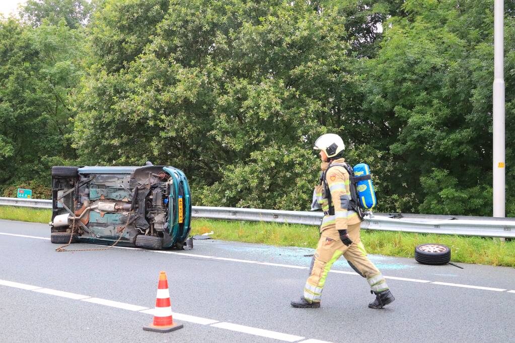 Auto glijdt over vangrail heen en belandt op zijn kop