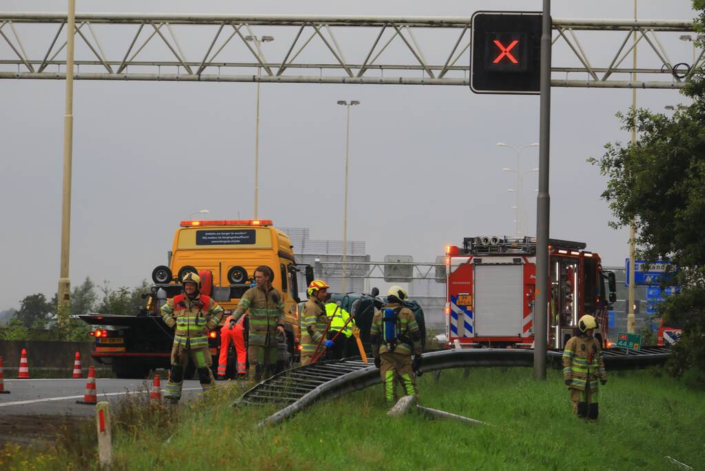 Auto glijdt over vangrail heen en belandt op zijn kop