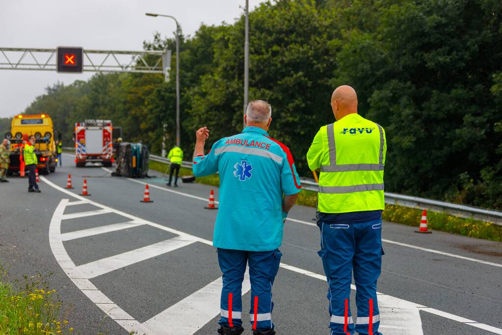 Auto glijdt over vangrail heen en belandt op zijn kop