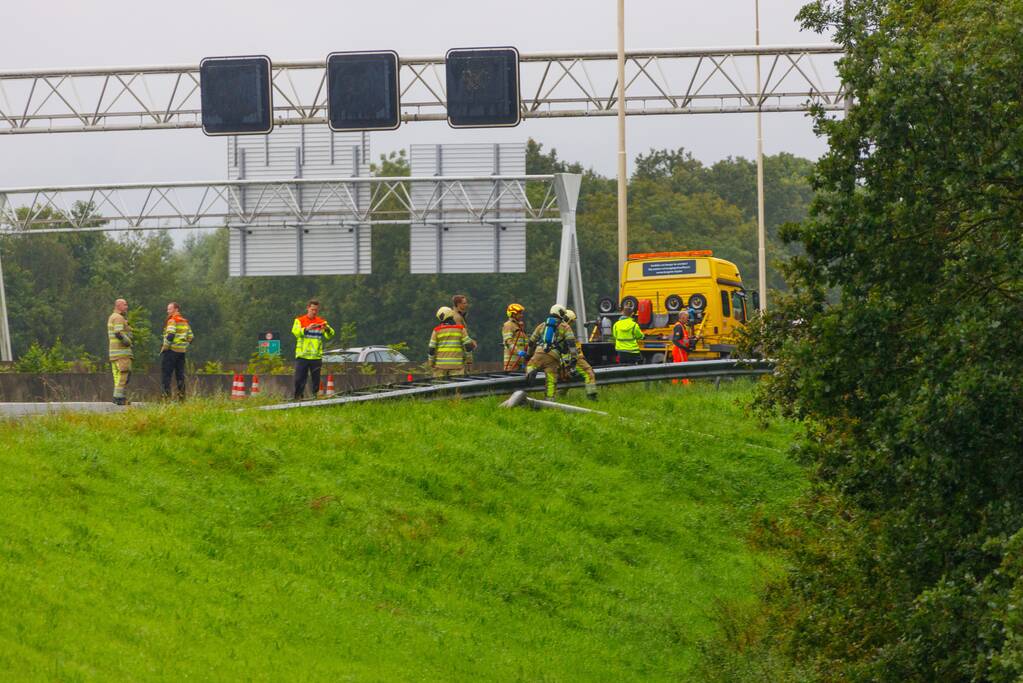 Auto glijdt over vangrail heen en belandt op zijn kop