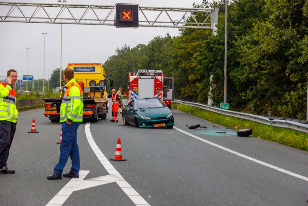 Auto glijdt over vangrail heen en belandt op zijn kop