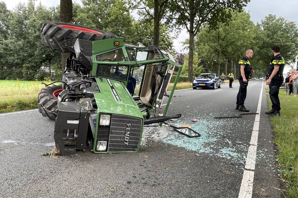 Tractor over de kop na botsing met boom
