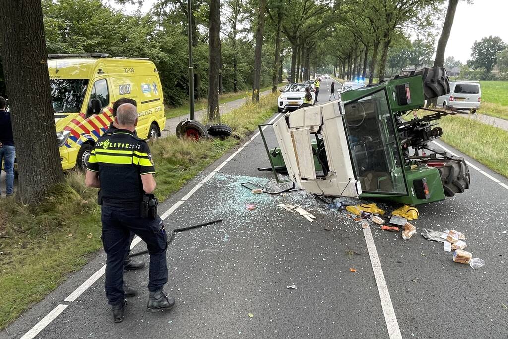 Tractor over de kop na botsing met boom