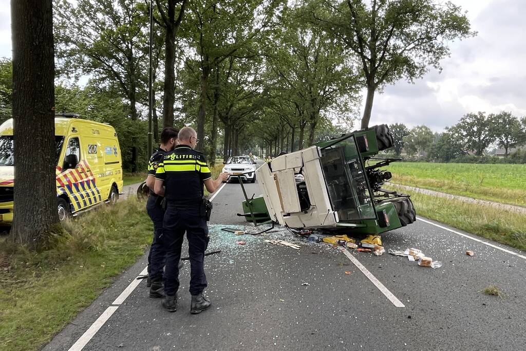 Tractor over de kop na botsing met boom