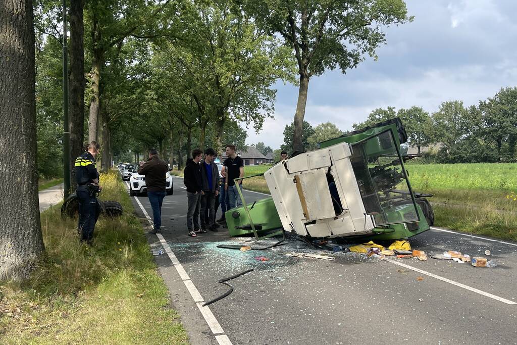 Tractor over de kop na botsing met boom