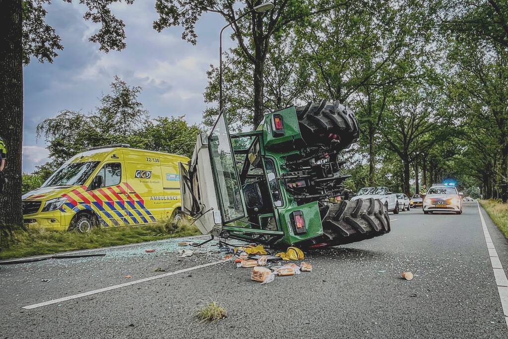 Tractor over de kop na botsing met boom