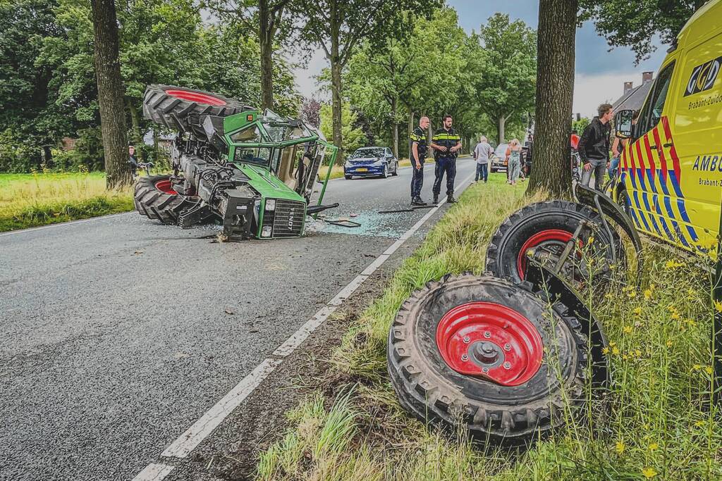 Tractor over de kop na botsing met boom