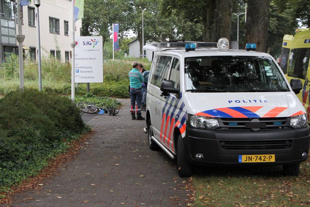 Vrouw met fiets gaat onderuit voor ingang ziekenhuis