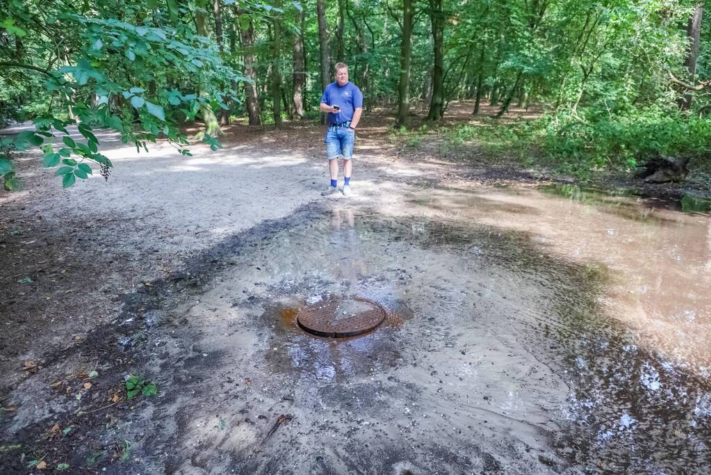 Putdeksel komt omhoog en zorgt voor wateroverlast op bospad