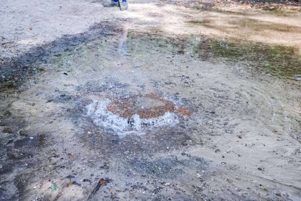 Putdeksel komt omhoog en zorgt voor wateroverlast op bospad