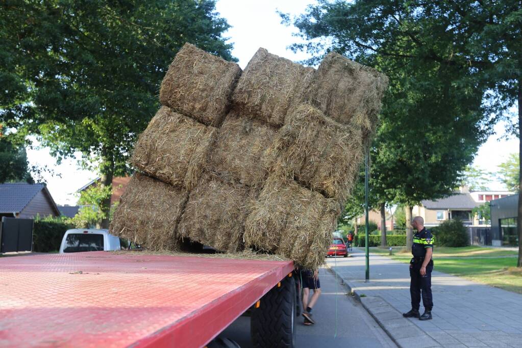 Kar met hooibalen dreigt om te vallen