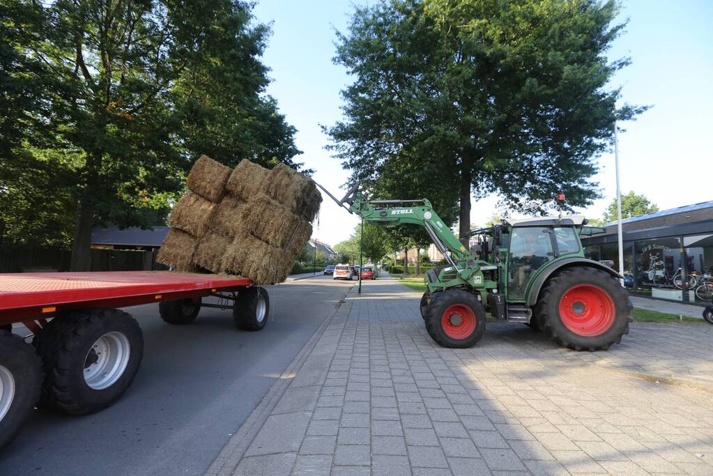 Kar met hooibalen dreigt om te vallen
