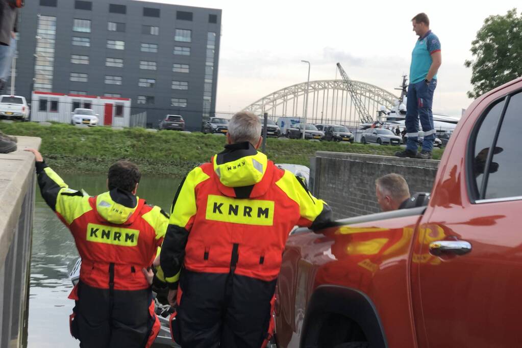 Omgeslagen boot wordt opgetakeld in jachthaven