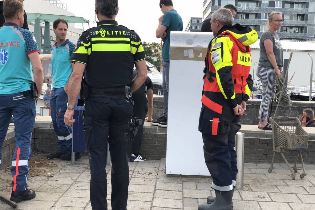 Omgeslagen boot wordt opgetakeld in jachthaven