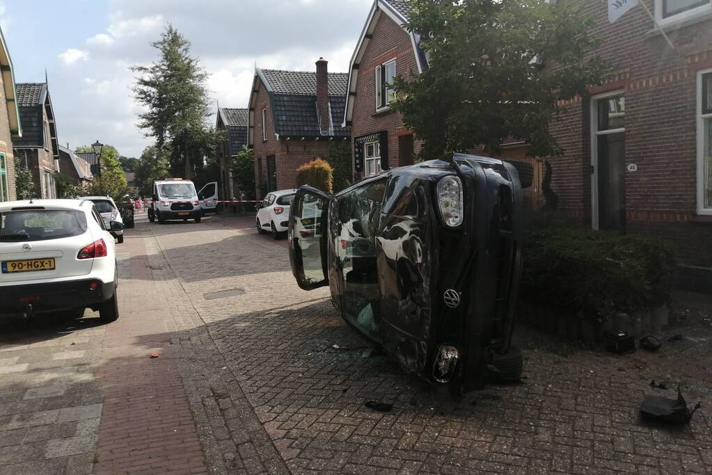 Personenauto belandt op zijn zijkant in woonwijk