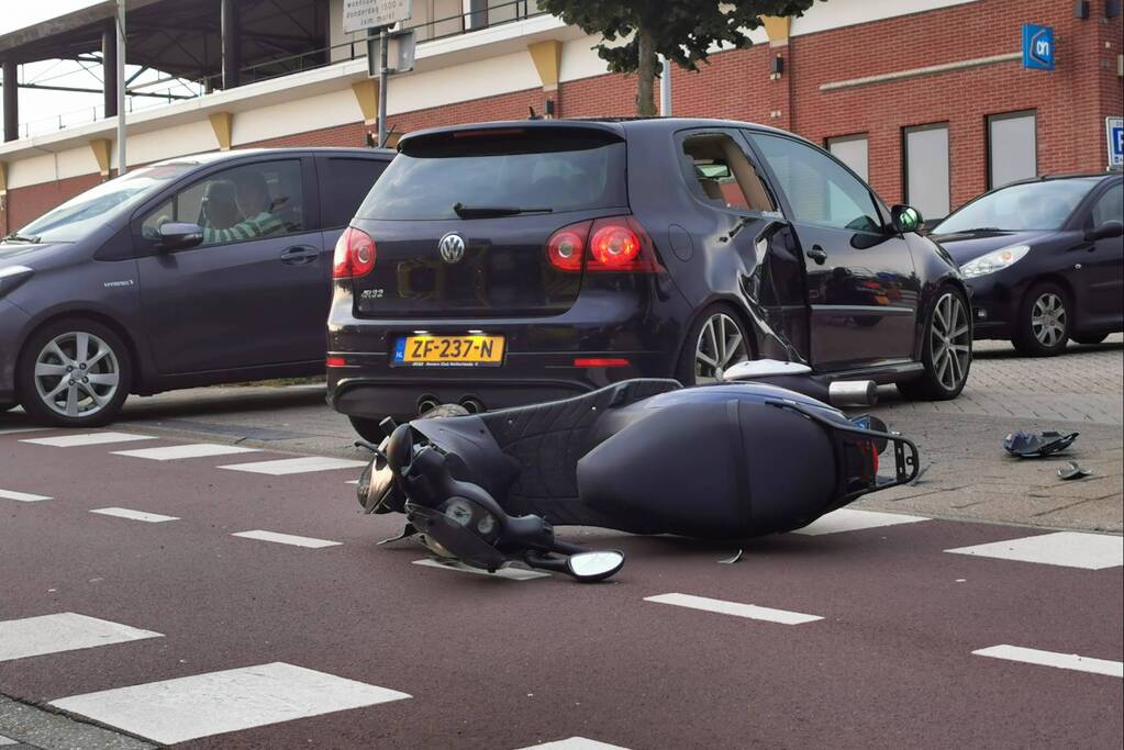 Scooter en auto botsen op elkaar
