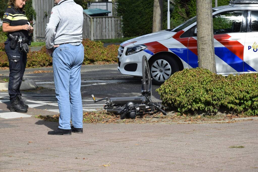Oude vrouw valt van fiets af