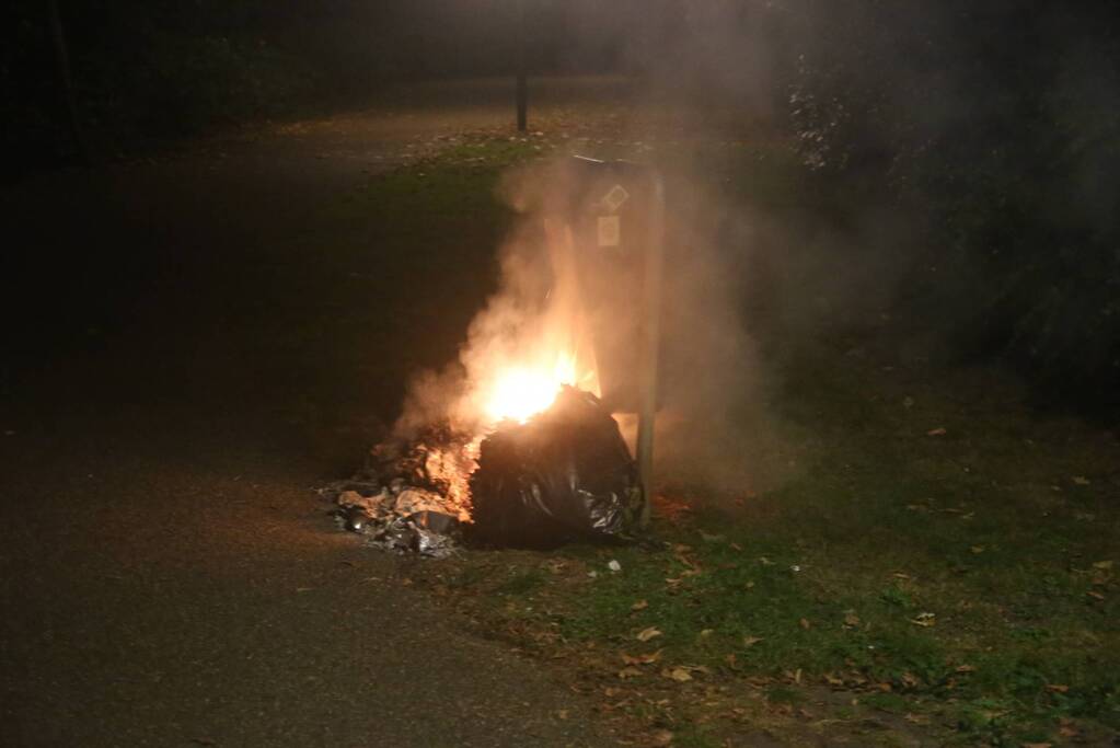 Brandweer blust brand bij prullenbak