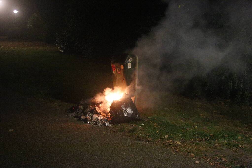 Brandweer blust brand bij prullenbak
