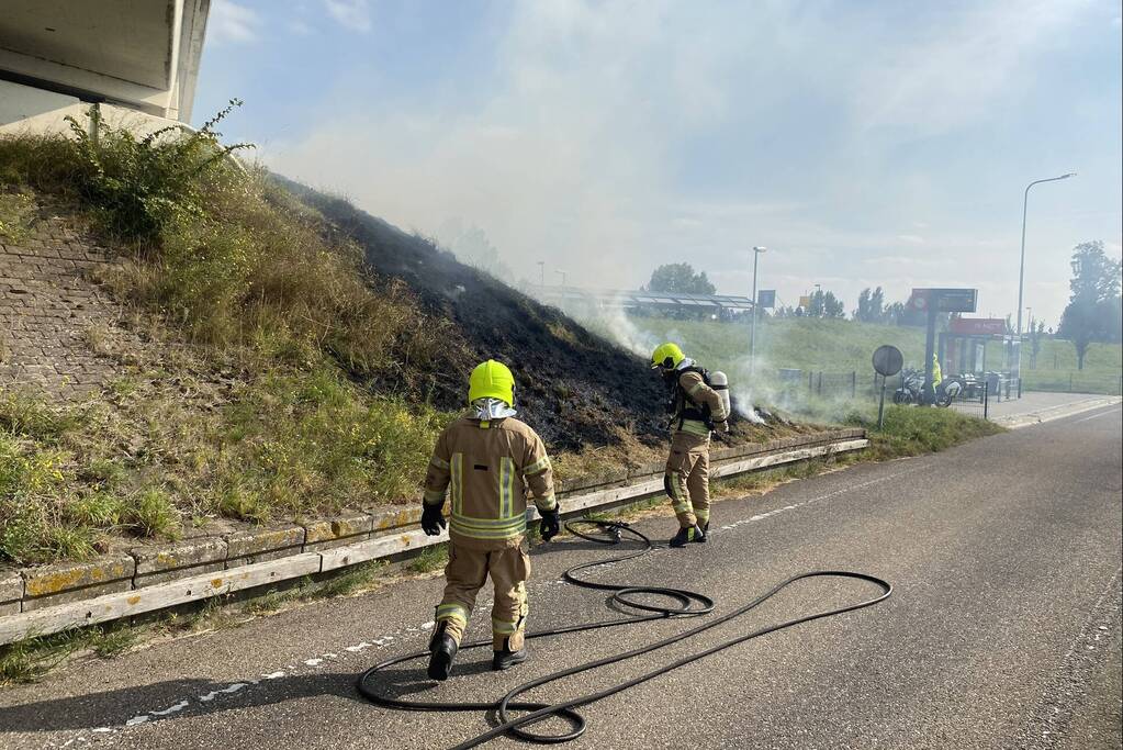 Berm talud naast snelweg vat vlam