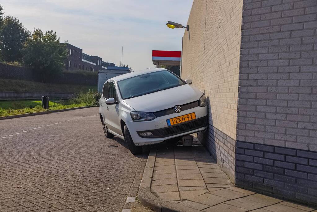 Auto rijdt tegen gevel Esso-tankstation aan