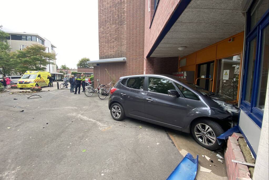 Vrouw botst met auto op gevel van wooncomplex