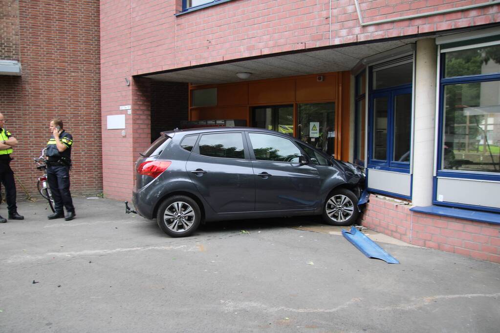 Vrouw botst met auto op gevel van wooncomplex
