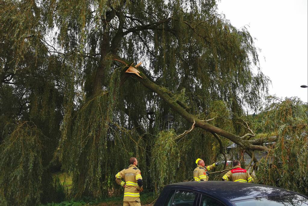 Tak breekt af en belandt op auto