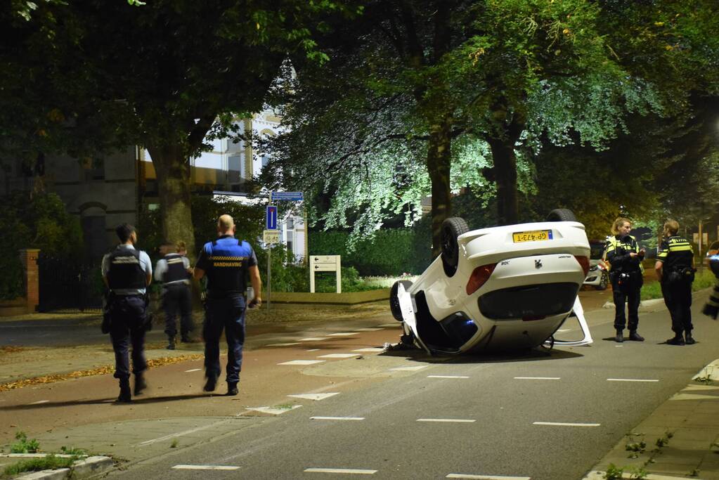 Auto op zijn kop tot stilstand na botsing tegen paal