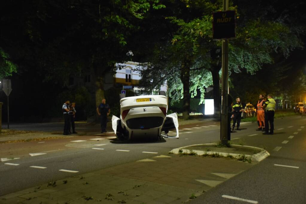 Auto op zijn kop tot stilstand na botsing tegen paal