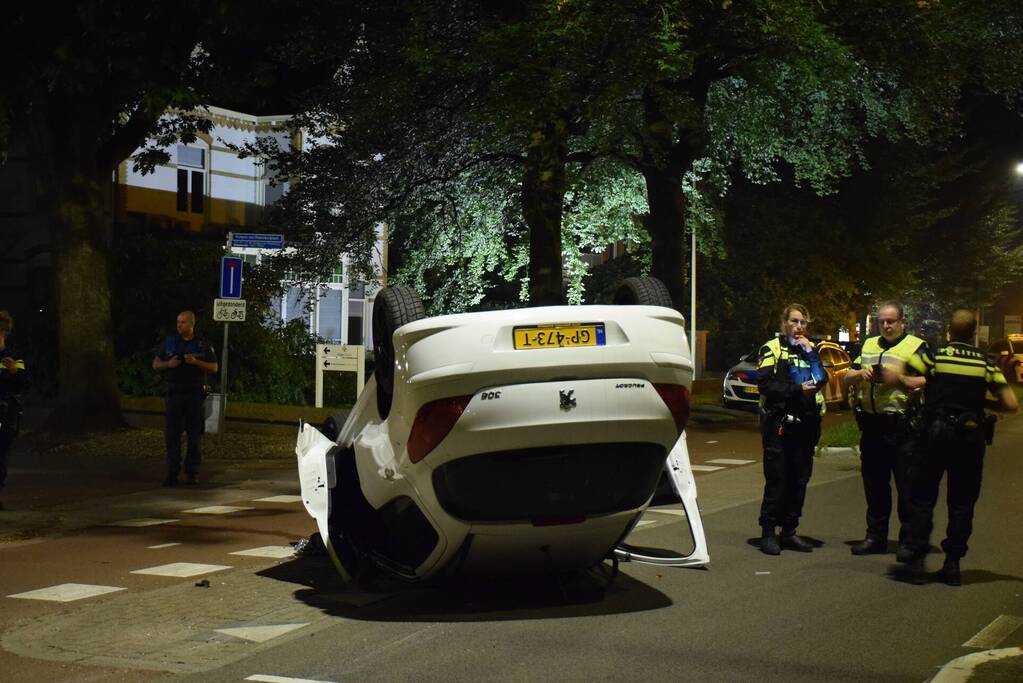 Auto op zijn kop tot stilstand na botsing tegen paal