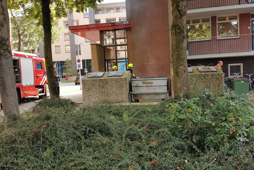 Brandweer blust brand in papiercontainer