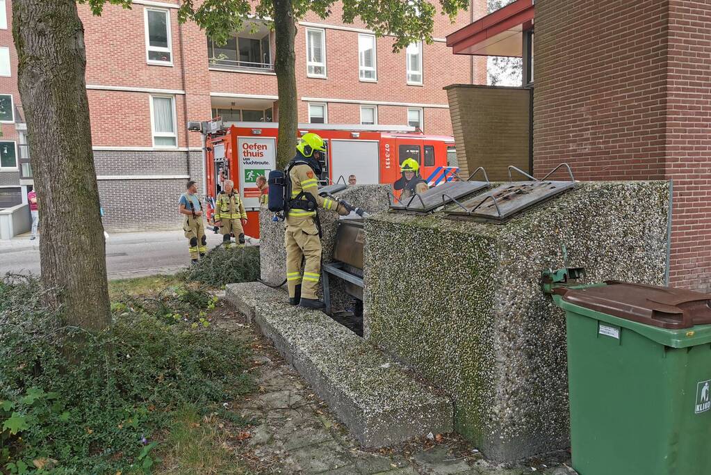 Brandweer blust brand in papiercontainer